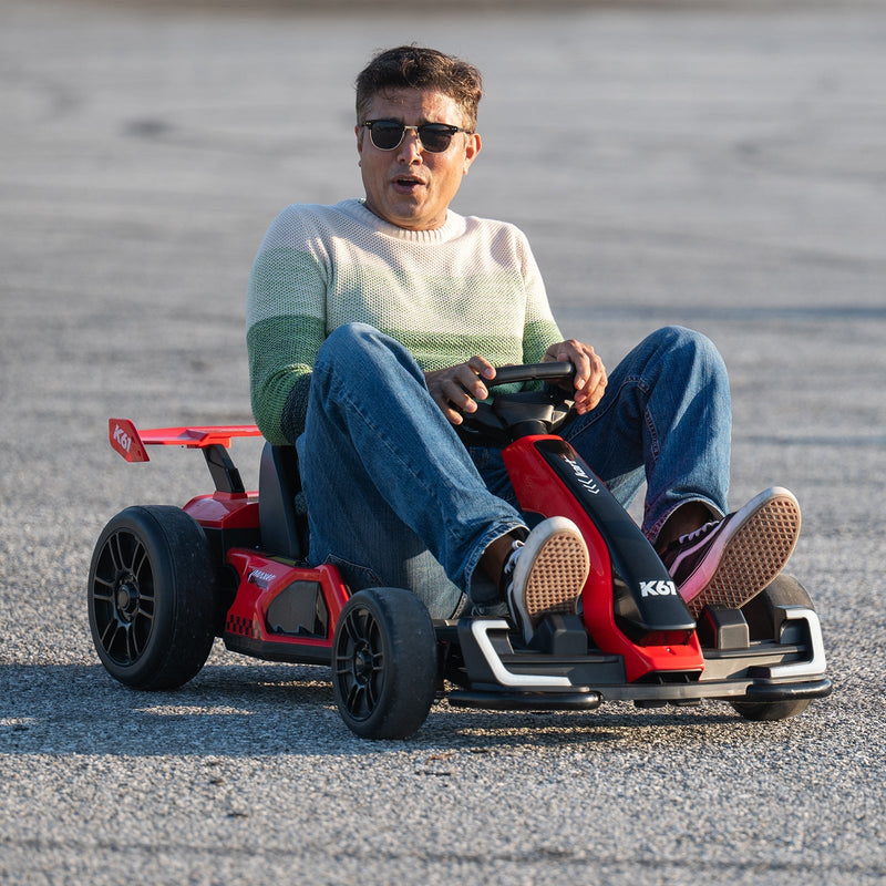 A person driving a red and black KerryYoo K61 electric drift kart on an open paved lot